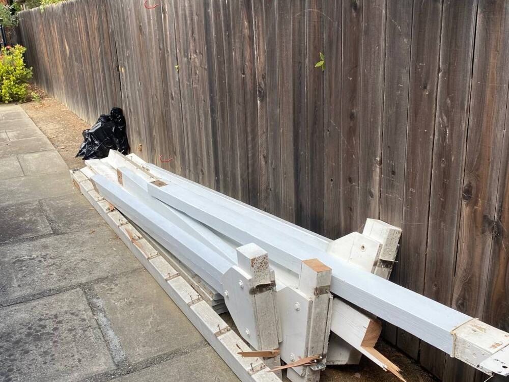 Before: scrap lumber stacked along a side walkway