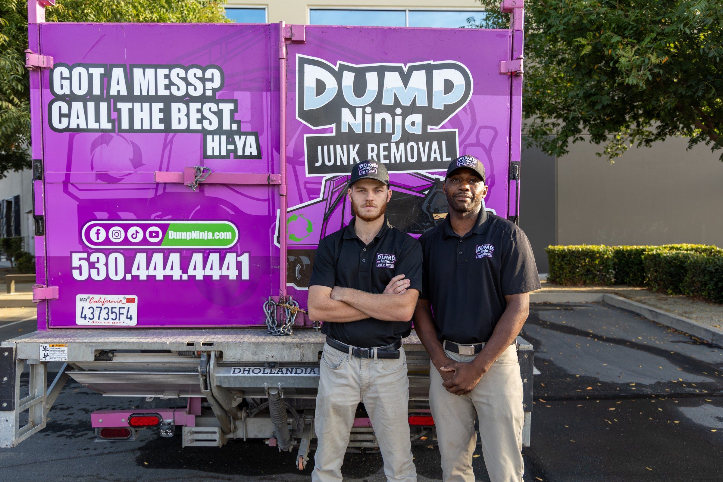 The Dump Ninja crew standing in front of the magenta truck