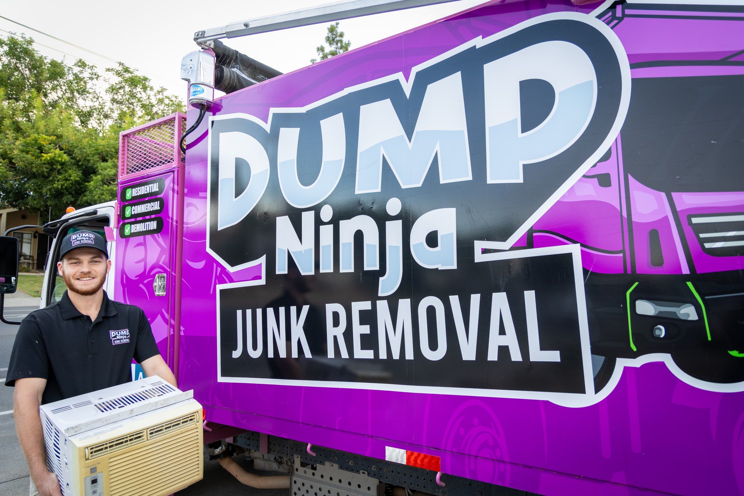 Dump Ninja crew member carrying a microwave to the truck for recycling