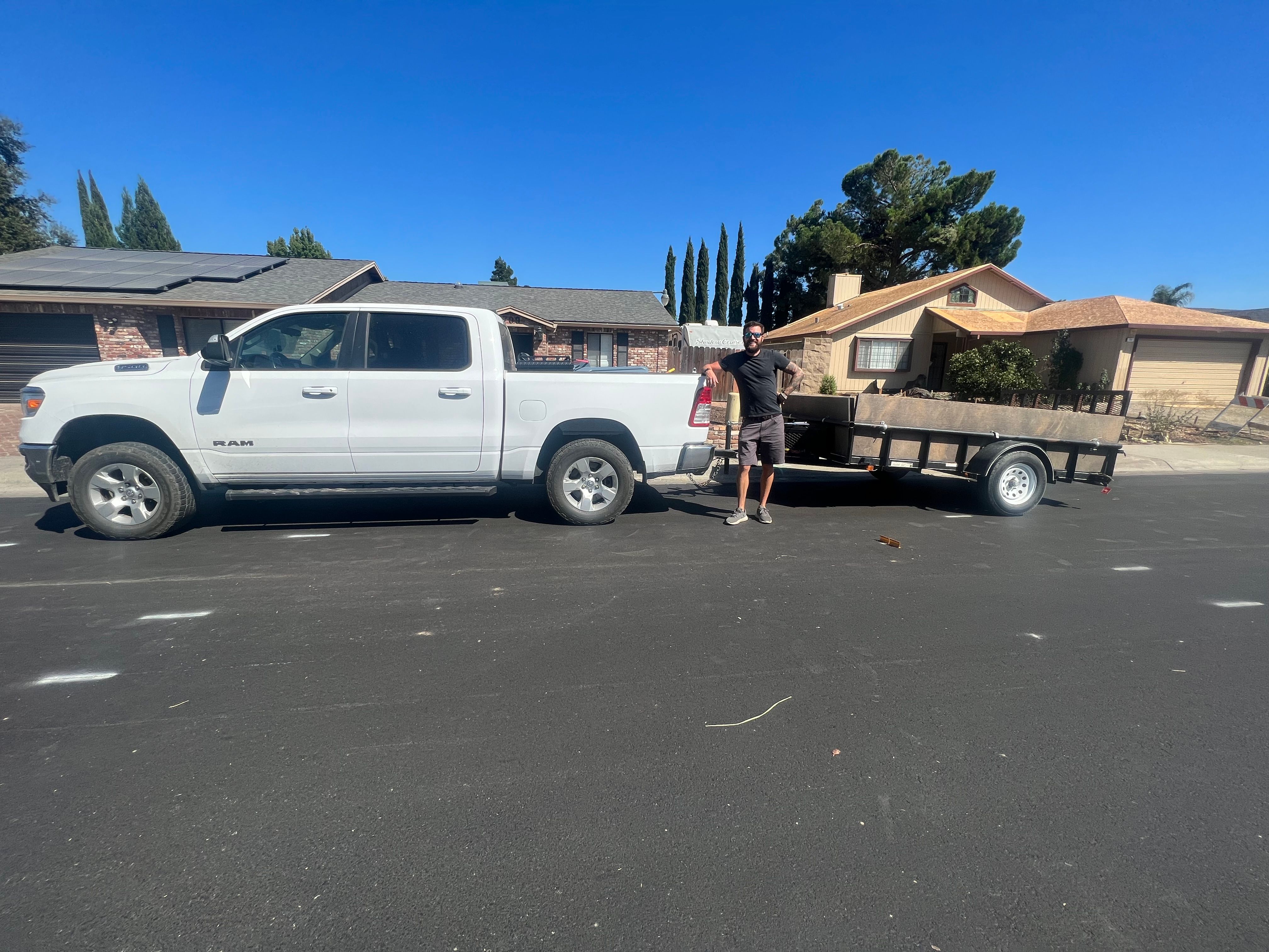 Jeremy beside the original white pickup and utility trailer when he started Dump Ninja