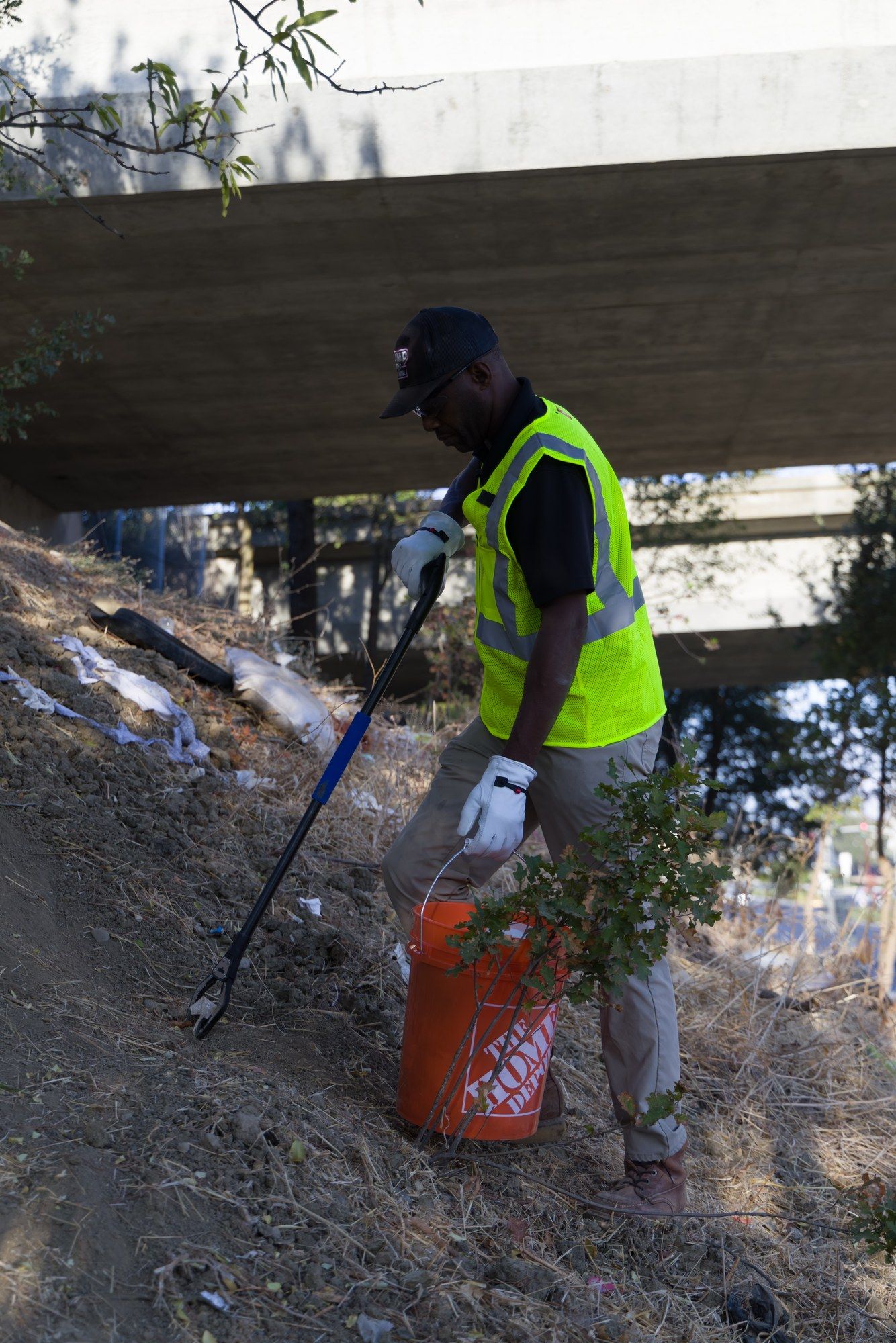 Dump Ninja crew member picking litter under an overpass in the Sacramento Valley
