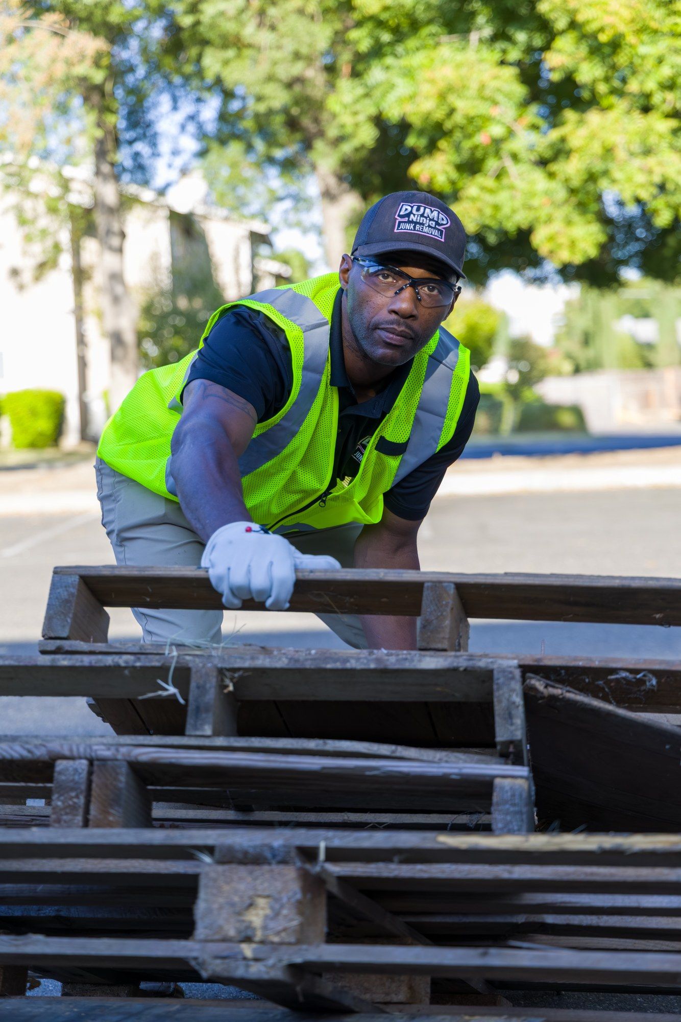 A Dump Ninja crew member breaking down abandoned pallets on a commercial property