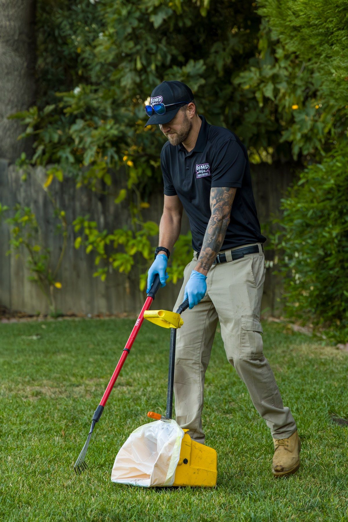Dump Ninja crew member scooping dog waste into a bagged pan during a one-time yard cleanup in Woodland