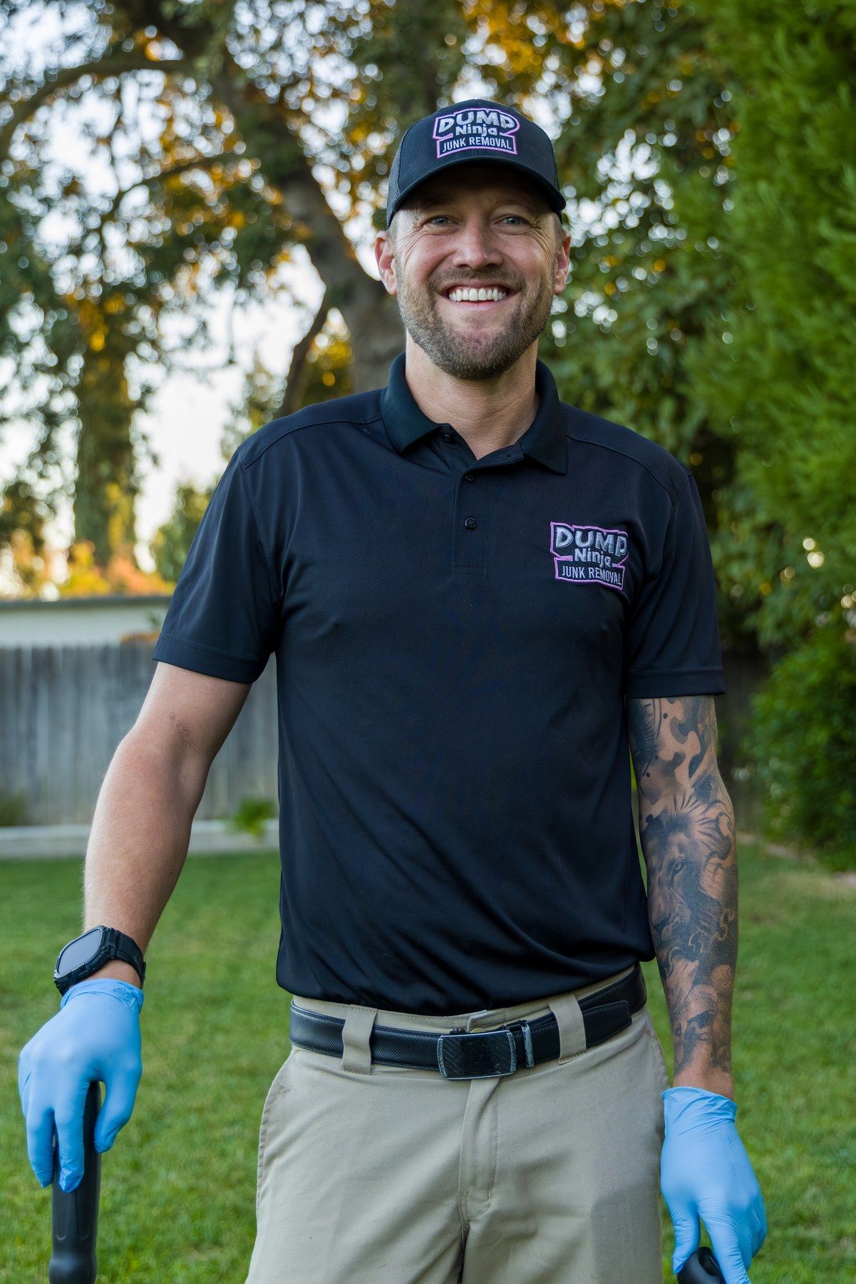 Smiling Dump Ninja crew member in blue gloves and navy polo ready for a pet waste route in Woodland