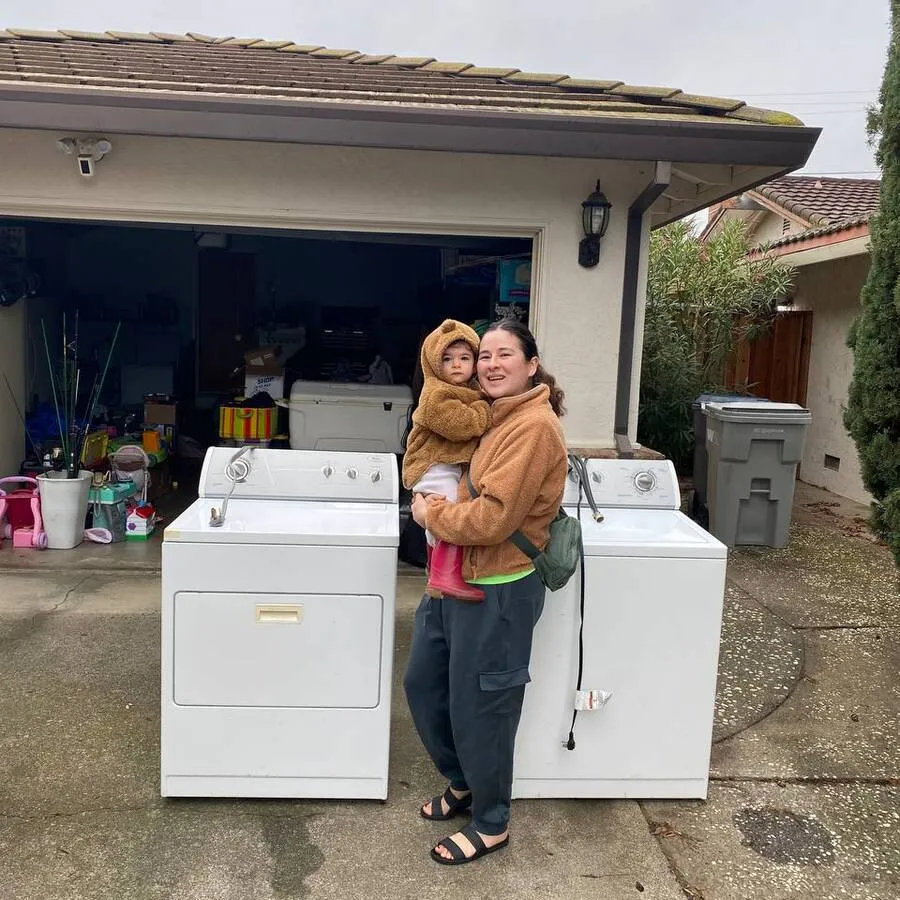 A mother and child with the washer and dryer set they won